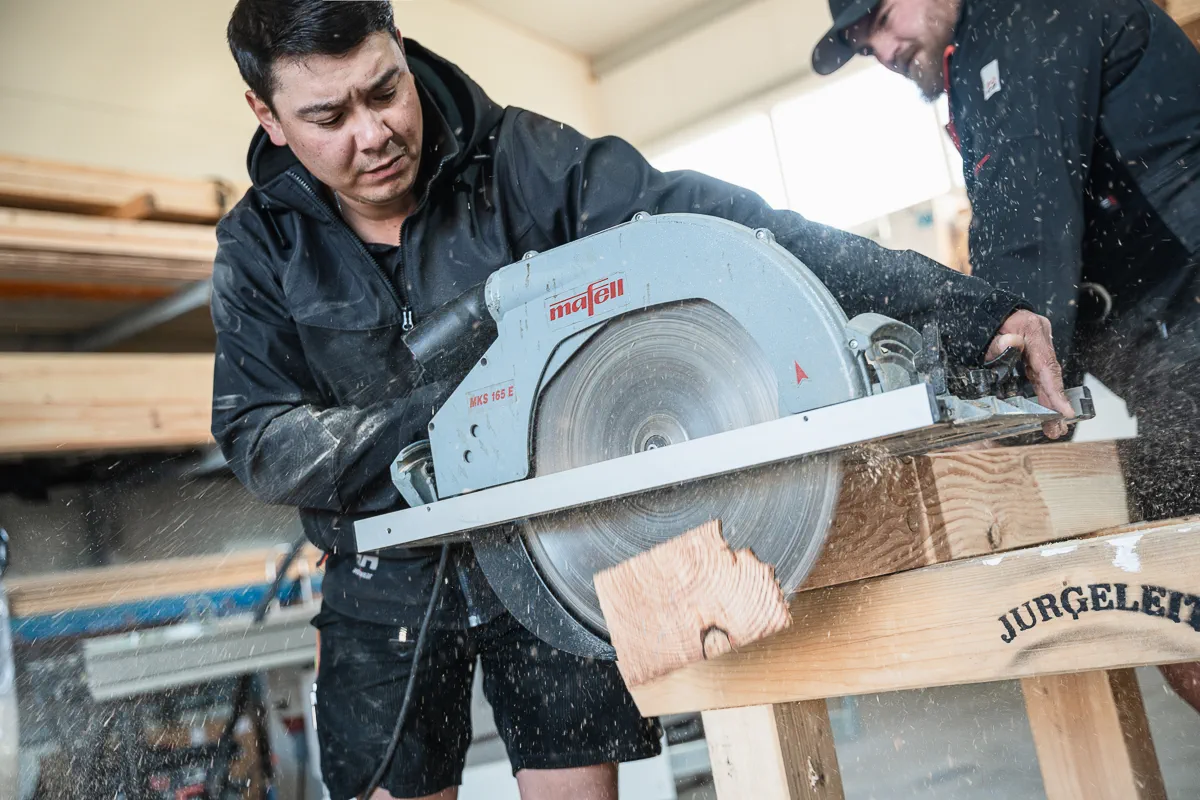 Handwerker von Holzmontagebau Jurgeleit bei gemeinsamer Arbeit an einer Holzkonstruktion