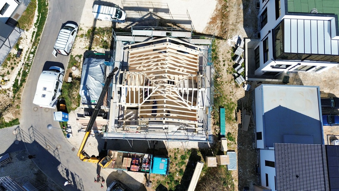  Drohnenaufnahme einer Holzmontage mit Kran bei einem Bauprojekt in Roggenburg 
